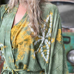 Person wearing a green and yellow patterned robe with a blurred background