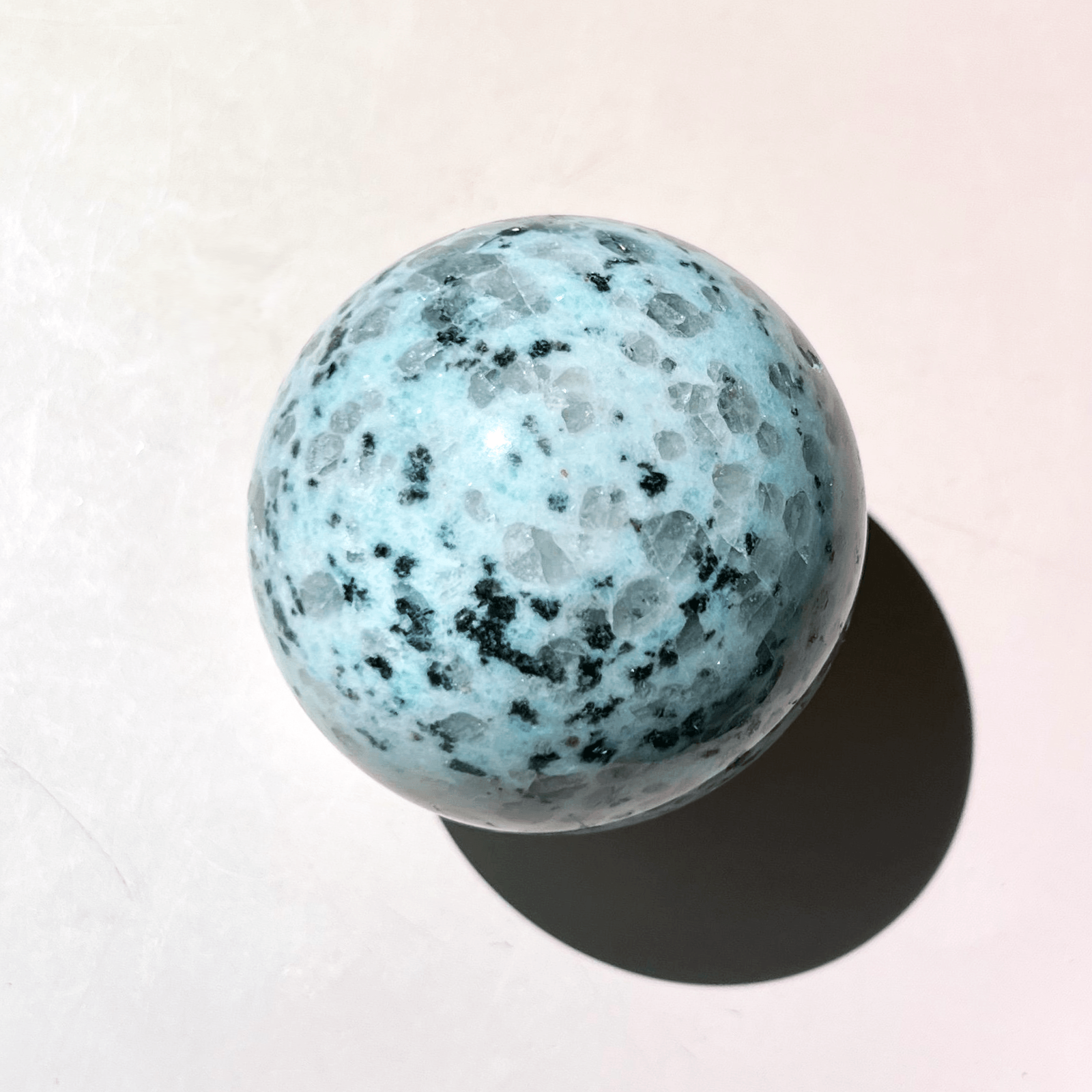 Multiple kiwi jasper crystal spheres in a row showing natural speckled patterns and sizes