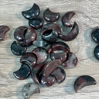 A pile of the mini garnet moons on a white wooden background.