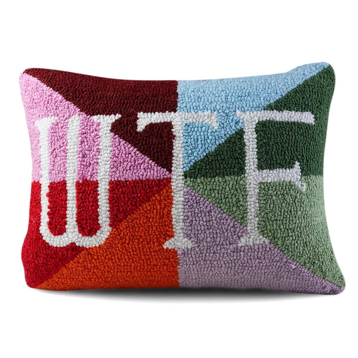 Close-up of needlepoint pillow with embroidered WTF lettering and textured stitching