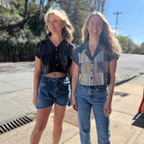 2 models smiling and wearing patchwork cropped blouses of different colors on a sidewalk