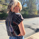 model looking over her shoulder with blonde hair and showing a side view of the cropped blouse