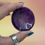 Amethyst Sphere stands in hands with orange and pink background