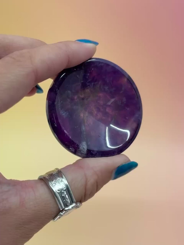 Amethyst Sphere stands in hands with orange and pink background