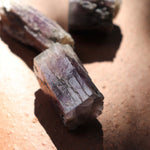 Close-up of a purple aragonite crystal on a brown surface