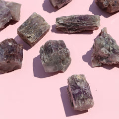 Mineral aragonite crystals on a pink background
