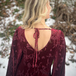 Raspberry red velvet 1970s maxi dress with dramatic fringe bell sleeves