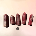 Multiple rhodochrosite crystal towers in different sizes with natural pink banding and patterns