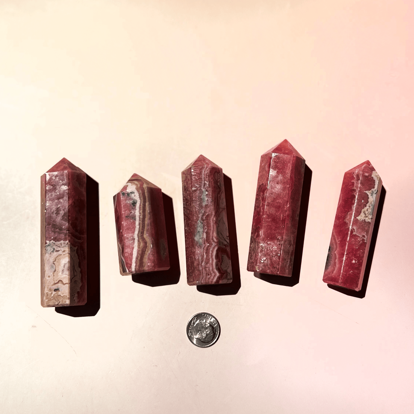 Multiple rhodochrosite crystal towers in different sizes with natural pink banding and patterns