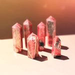 Group of rhodochrosite crystal towers displayed with rich pink and red natural patterns