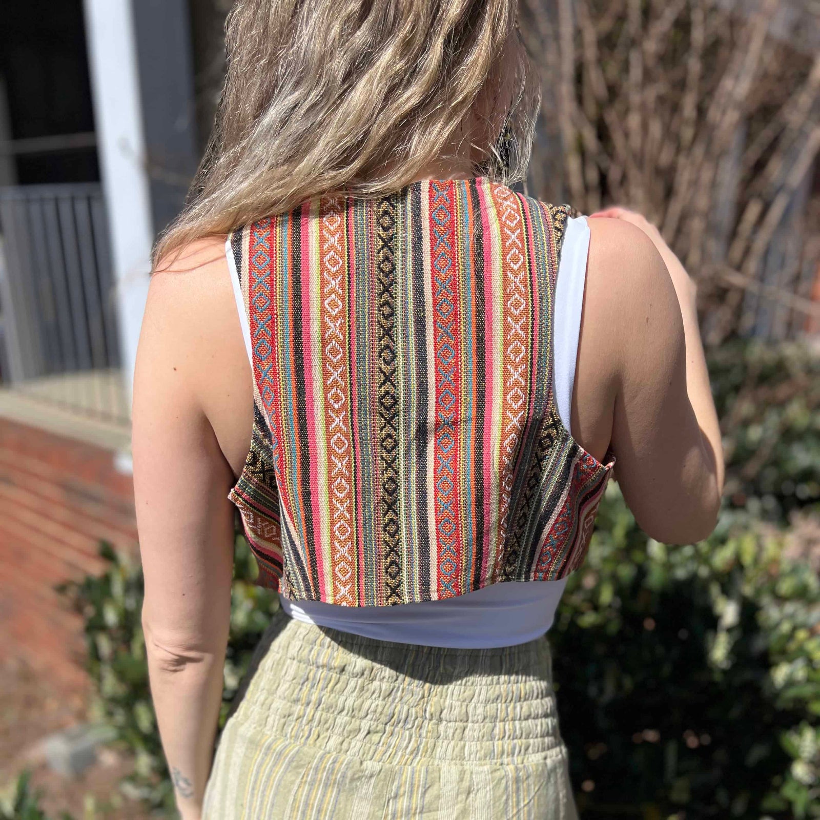 Rustic stripe fitted cotton vest - model turning to show back pattern detail of vest