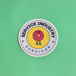 The Service Industry Restaurant Humor Sticker on a green background.