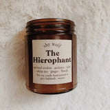 The Hierophant candle on a white fluffy surface.