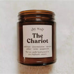 The Chariot candle on a white fluffy surface.