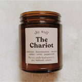 The Chariot candle on a white fluffy surface.