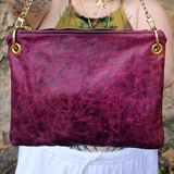 Someone holding the Distressed Blush Snakeskin and Leather Crossbody Bag showing off the back.