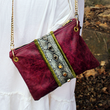 Someone wearing the Distressed Blush Snakeskin and Leather Crossbody Bag with a white skirt.