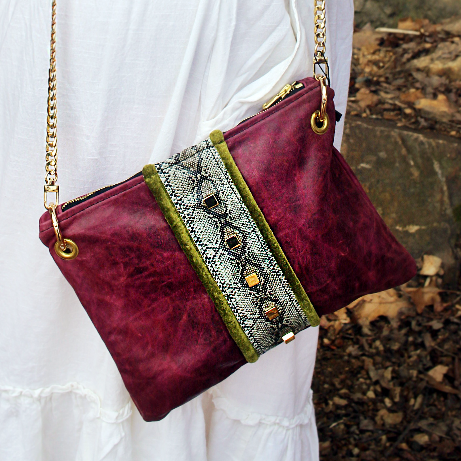 Someone wearing the Distressed Blush Snakeskin and Leather Crossbody Bag with a white skirt.