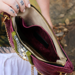 Someone holding the Distressed Blush Snakeskin and Leather Crossbody Bag open to show the inside.