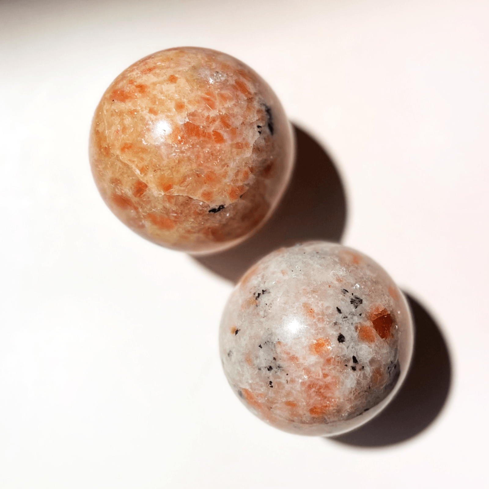 Close-up of sunstone sphere showing sparkling aventurescence and natural mineral inclusions
