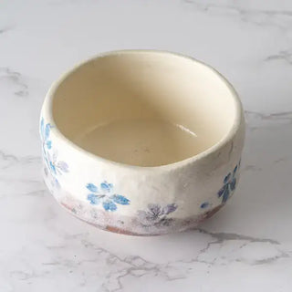 The Blue Sakura Cherry Blossoms Mini Matcha Bowl on a white marble background.