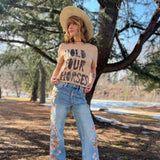 Close up of Hold Your Horses western graphic print on Bella Canvas sand dune t-shirt