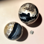 Volcano agate sphere used for grounding energy with natural layered patterns and earthy tones