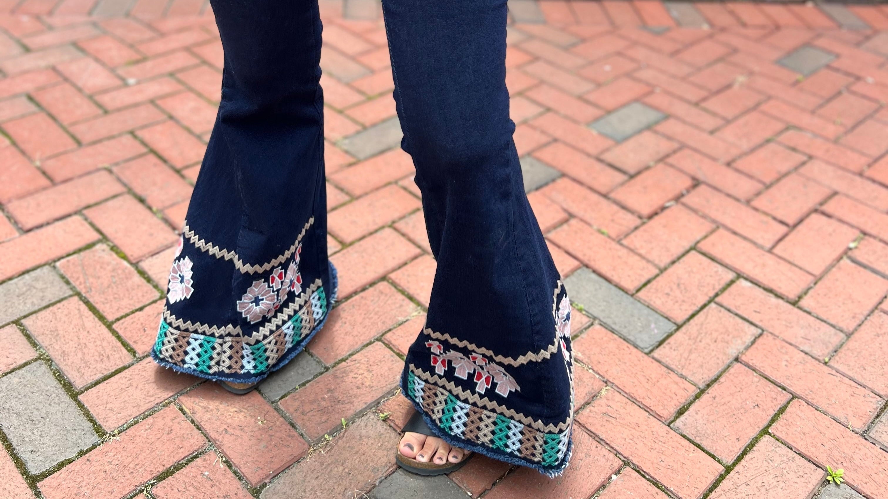 Woman wearing retro boho bell bottom pants with 70s inspired flared legs, styled for free-spirited fashion and festival outfits.