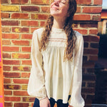 front view of woven long sleeve mock neck top with lace details in natural color
