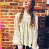 front view of woven long sleeve mock neck top with lace details in natural color